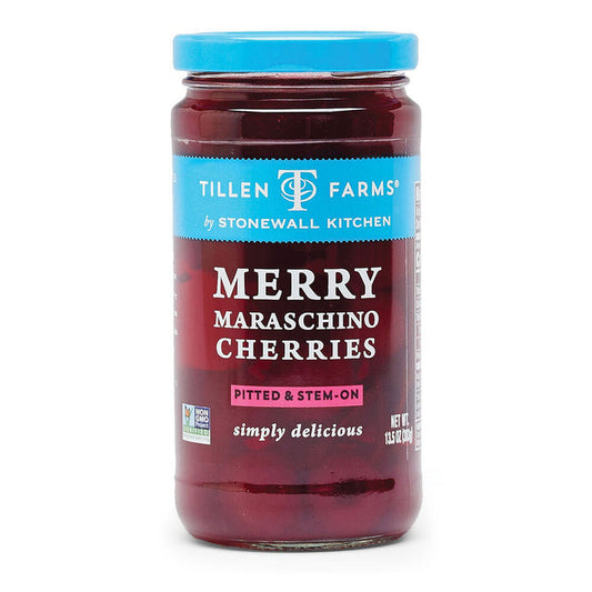 A jar of Stonewall Kitchen Merry Maraschino Cherries features a blue lid and label. These pitted, stem-on cherries are sourced from the Pacific Northwest. The label proudly displays "simply delicious" and "non-GMO" markers. Each jar has a net weight of 13.5 oz (383g).