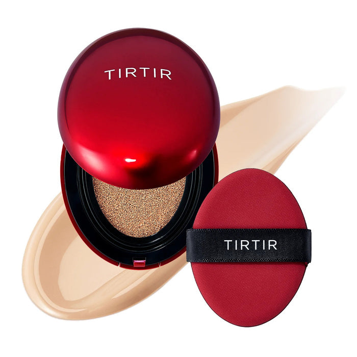An open red compact of KOSMIC KBEAUTY SKINCARE’s TIRTIR MASK FIT RED CUSHION FOUNDATION IN SAND, MINI displays a full coverage cushion foundation alongside a matching red applicator, with a beige smear of foundation visible in the background.