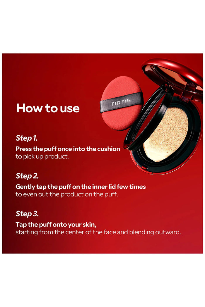 An open red compact of KOSMIC KBEAUTY SKINCARE’s TIRTIR MASK FIT RED CUSHION FOUNDATION IN SAND, MINI displays a full coverage cushion foundation alongside a matching red applicator, with a beige smear of foundation visible in the background.