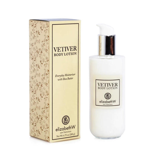 A bottle of E WIGHTMAN & CO VETIVER BODY LOTION with a pump stands beside its matching floral-patterned box. This shea butter moisturizer uses botanical extracts to hydrate and nourish your skin daily.