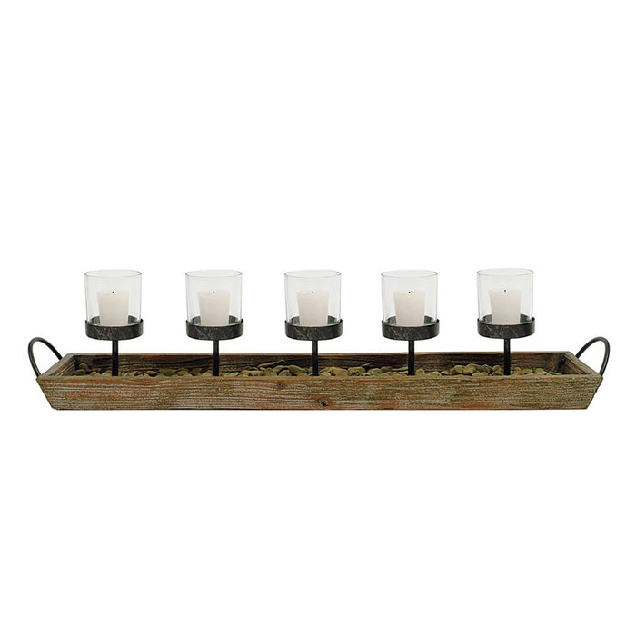 The CREATIVE COOP VOTIVE HOLDER features a rectangular wood and metal frame with handles, five white candles in glass votives on black stands, and decorative pebbles at the base—ideal for creating cozy fireplace ambience.
