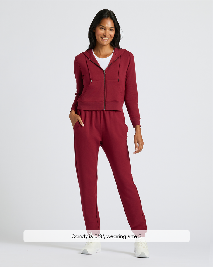 Model in Womens Dark Maroon Relaxed Joggers with hoodie and sneakers.