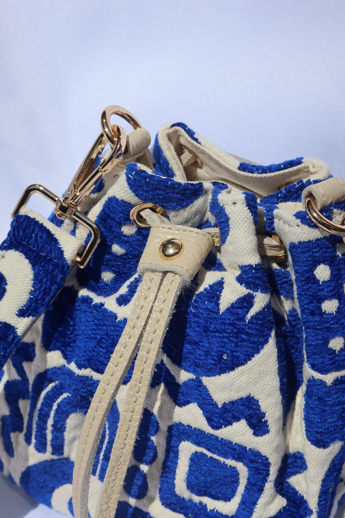 Cream and royal blue bucket bag with geometric shapes and a leather drawstring with an adjusble crossbody strap made in Greece