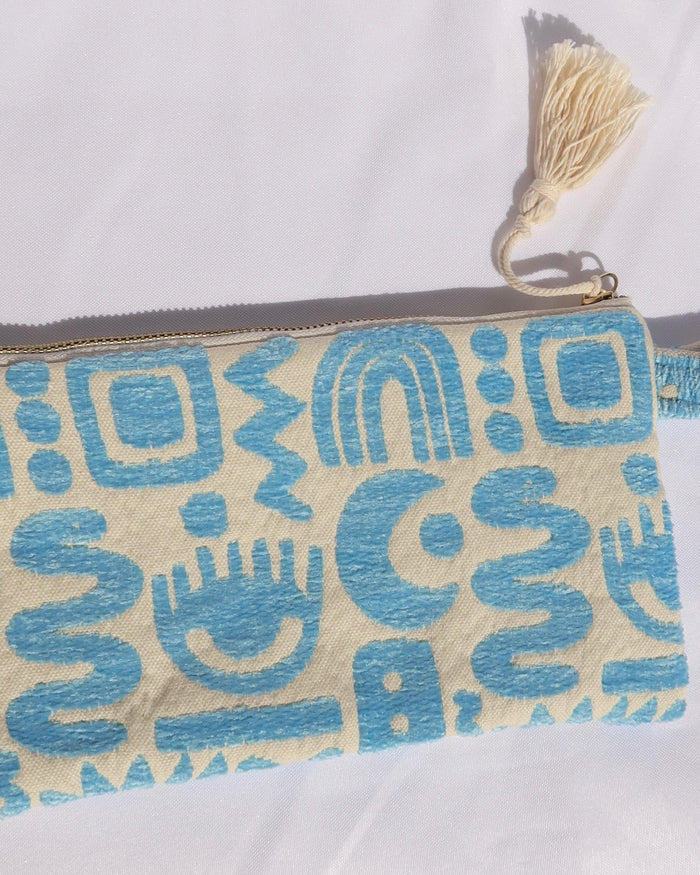 Woven cotton clutch bag wristlet with turquoise geometric print featuring evil eyes, rainbows, snakes, moons, and more made in Greece. Greek fashion accessory zipper pouch with tassel