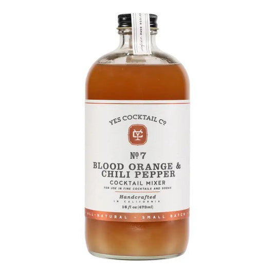 A glass bottle of YES COCKTAIL CO - BLOOD ORANGE AND CHILI PEPPER COCKTAIL MIXER by YES COCKTAIL CO., featuring blood orange juice and a hint of ancho chili pepper. The label indicates it's handcrafted, all-natural, and small-batch. This 16 fl oz (473 ml) mixer is perfect for creating fine cocktails and spicy margaritas.